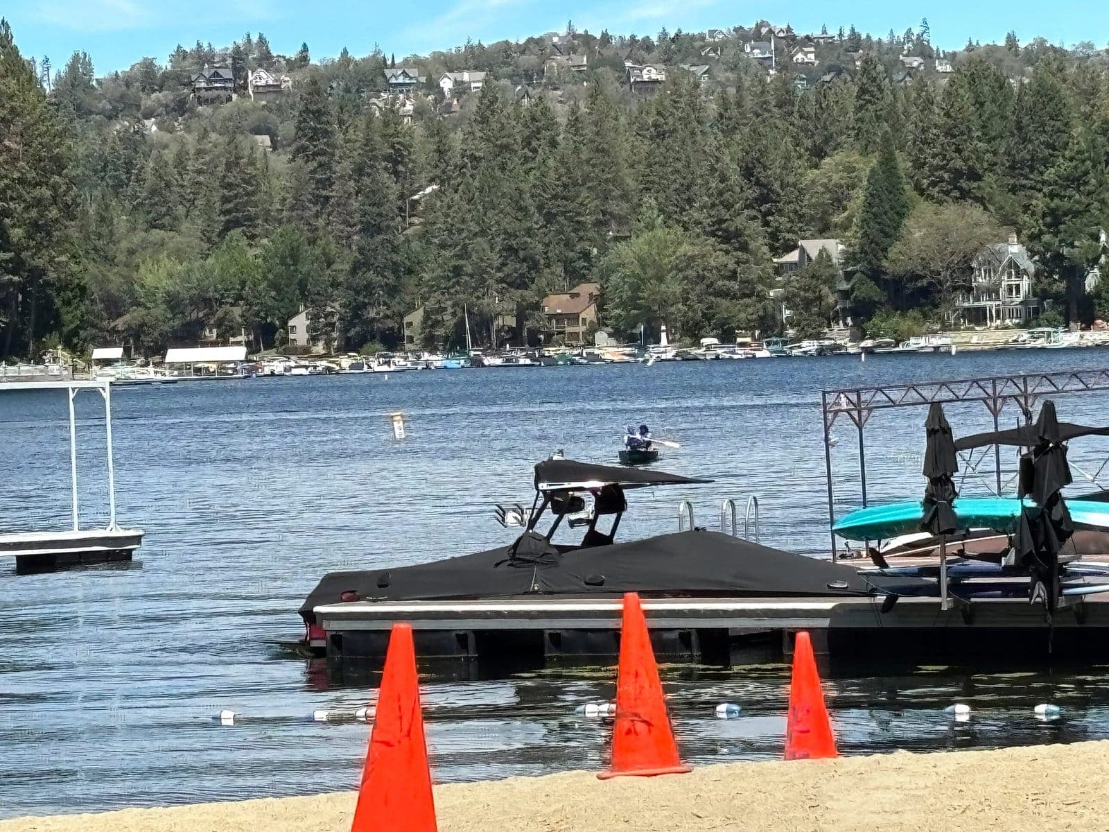 Lake Arrowhead seen from the water, with docks and pine trees on the far shore.